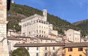 a large white building with a mountain in the background at Gorgeous Apartment In Gubbio With Wifi in Gubbio