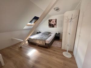 1 dormitorio con 1 cama en una habitación con escaleras en Ferienwohnungen Auf der Höhe, en Engelsbrand