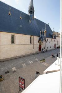 een grote witte kerk met een zwart dak bij Le Pavean in Beaune