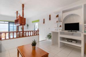 a living room with a television and a table at Faro de Sardina Frente al Mar in Gáldar