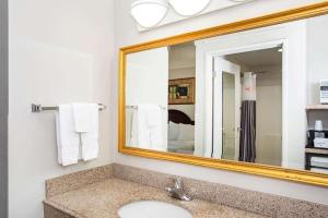 a bathroom with a sink and a mirror at La Quinta by Wyndham Melbourne Viera in Melbourne
