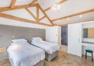2 camas en una habitación con techos de madera en River View Lodge, en Allendale