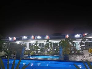 a house with a swimming pool at night at MB House in Ban Nai Rai