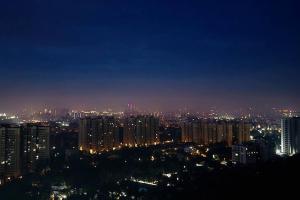 uma vista para uma cidade à noite com luzes em A Night in PÂRIS on the 31st Floor em Yelahanka
