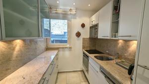 a kitchen with white cabinets and a sink and a window at Ascona Bellavista in Ascona