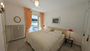 a bedroom with a bed and a large window at Ascona Bellavista in Ascona