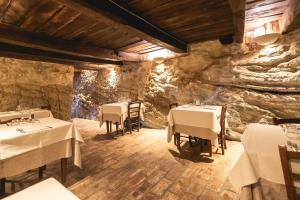 un restaurante con mesas y sillas en una pared de piedra en Locanda dell'Ambra - Eleganza Rustica nel cuore della Romagna en Talamello