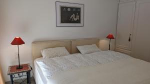 a bedroom with a bed with two lamps on a table at Ascona Bellavista in Ascona +11 photos