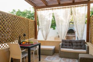 eine Terrasse mit einem Tisch, Stühlen und einem Sofa in der Unterkunft Appartamenti Leone in San Vito lo Capo