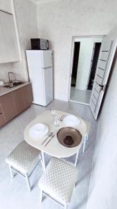 a kitchen with a white table and two chairs at Mountain View One in Tashkent