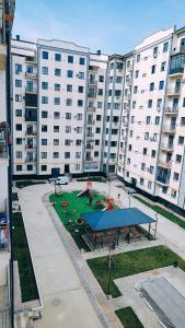 a park with a playground in front of a large building at Mountain View One in Tashkent