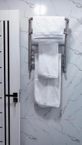 a bathroom with white towels hanging on a wall at Mountain View One in Tashkent