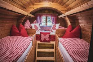 a bedroom with two beds in a wooden house at Schlafen im Fass - Schlaffass - Abenteuer - Romantik - Haslifass in Innertkirchen