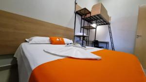 ein orangefarbenes und weißes Bett in einem Zimmer in der Unterkunft Achei Casa 6: Seu espaço exclusivo em Porto Velho in Porto Velho