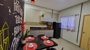 a kitchen with a table with red plates on it at Achei Casa 6: Seu espaço exclusivo em Porto Velho in Porto Velho
