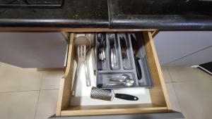 a kitchen utensils in a drawer under a counter at Achei Casa 6: Seu espaço exclusivo em Porto Velho in Porto Velho