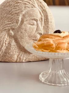 a pastry on a plate next to a statue at FUTURA ROOM&RELAX in Termoli