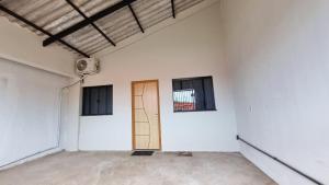 an empty room with a door and two windows at Achei Casa 6: Seu espaço exclusivo em Porto Velho in Porto Velho +5 photos