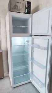 a white refrigerator with its door open in a kitchen at Mountain View One in Tashkent