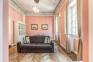 uma sala de estar com um sofá de couro e paredes cor-de-rosa em La Rosa em Florença
