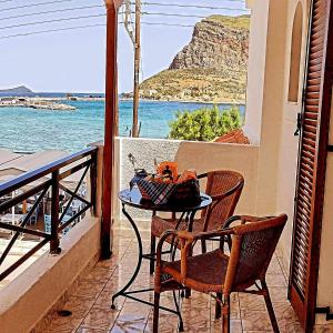 una mesa y sillas en un balcón con vistas al océano en AGNANTIO en Monemvasia