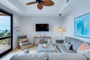 a living room with a couch and a ceiling fan at Rooftop balcony oceanfront PH condo with King beds in Jacó