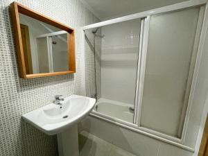 a white bathroom with a sink and a shower at Apartamentos Estacion Oropesa 3000 in Oropesa del Mar +40 photos