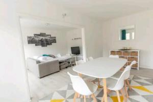 une salle à manger blanche avec une table et des chaises blanches dans l'établissement * Cosy & Spacieux * (75 M2) RER D à 5 min à pied, à Corbeil-Essonnes