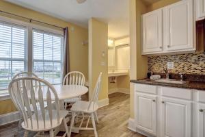 a kitchen with a table and chairs and a sink at Unit 112D at Tiffany's in Surf City