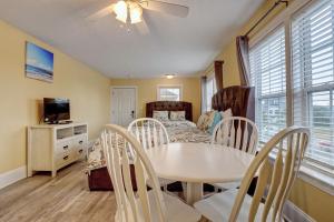 a dining room with a table and chairs and a bedroom at Unit 112D at Tiffany's in Surf City
