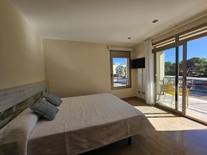 a bedroom with a large bed and a balcony at Antonia in Can Picafort