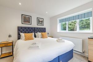 a bedroom with a large bed and a window at Number Five Hardwood Knoll House in Cromer