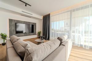 a living room with a couch and a flat screen tv at Luxury Villa Kaia with heated pool and SPA in Vodice