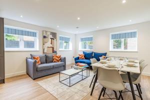 a living room with a table and a couch at Number Five Hardwood Knoll House in Cromer