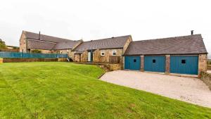 a row of houses with blue doors and a yard at Manifold Barns in Belper