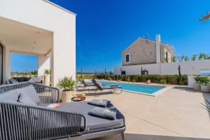 a patio with a couch and a swimming pool at Luxury Villa Kaia with heated pool and SPA in Vodice