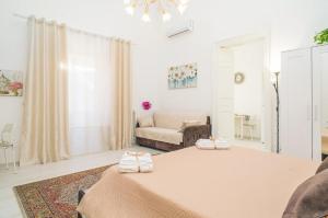 a white room with a bed and a couch at L'Antico Cortile di Alba in Viagrande