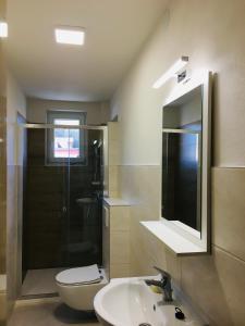 a bathroom with a sink and a toilet and a mirror at Rodinný RETRO domček in Dolný Kubín