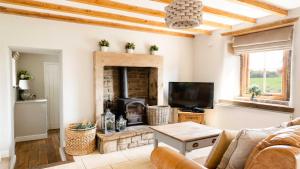 a living room with a couch and a fireplace at Lapwing Barns in Longnor