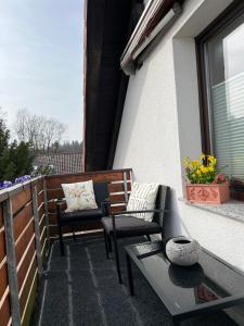 a patio with two chairs and a table on a balcony at Ferienwohnung Nannerl in Bad Sachsa