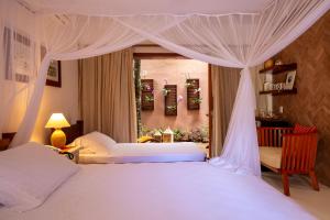 - une chambre avec 2 lits et un lit à baldaquin dans l'établissement Pousada Quarto Crescente, à Trancoso