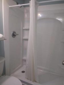 ein weißes Bad mit einer Dusche und einem WC in der Unterkunft Unit 206SD at Tiffany's in Surf City