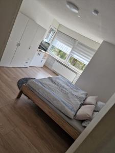 een bed in een kamer met 2 ramen bij Ferienwohnung Kleve Kellen in Kleve