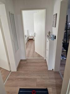 克萊沃的住宿－Ferienwohnung Kleve Kellen，走廊上设有白色门,铺有木地板