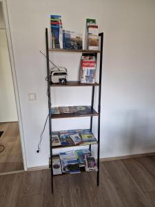 een boekenplank gevuld met boeken naast een muur bij Ferienwohnung Kleve Kellen in Kleve