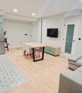 a living room with a table and a tv at Laralva Home in Pontevedra
