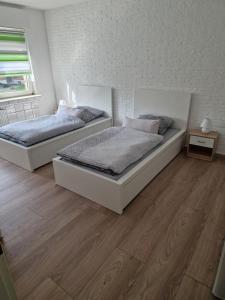 twee bedden in een slaapkamer met een houten vloer bij Ferienwohnung Kleve Kellen in Kleve