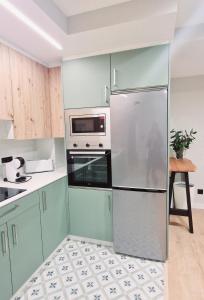 a kitchen with green cabinets and a refrigerator at Laralva Home in Pontevedra