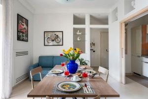 una mesa de comedor con un jarrón azul de flores en Appartamento Le Zagare, en Sorrento