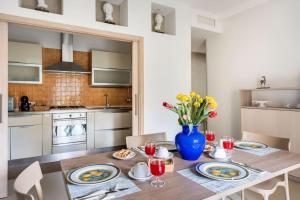una cocina con una mesa de madera y un jarrón de flores en Appartamento Le Zagare, en Sorrento